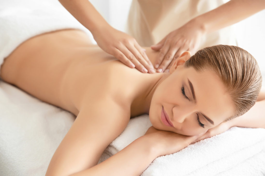 Young beautiful blonde woman having a back massage in spa salon
