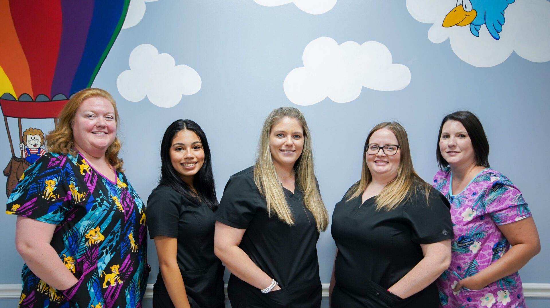 four women in scrubs are posing for a picture