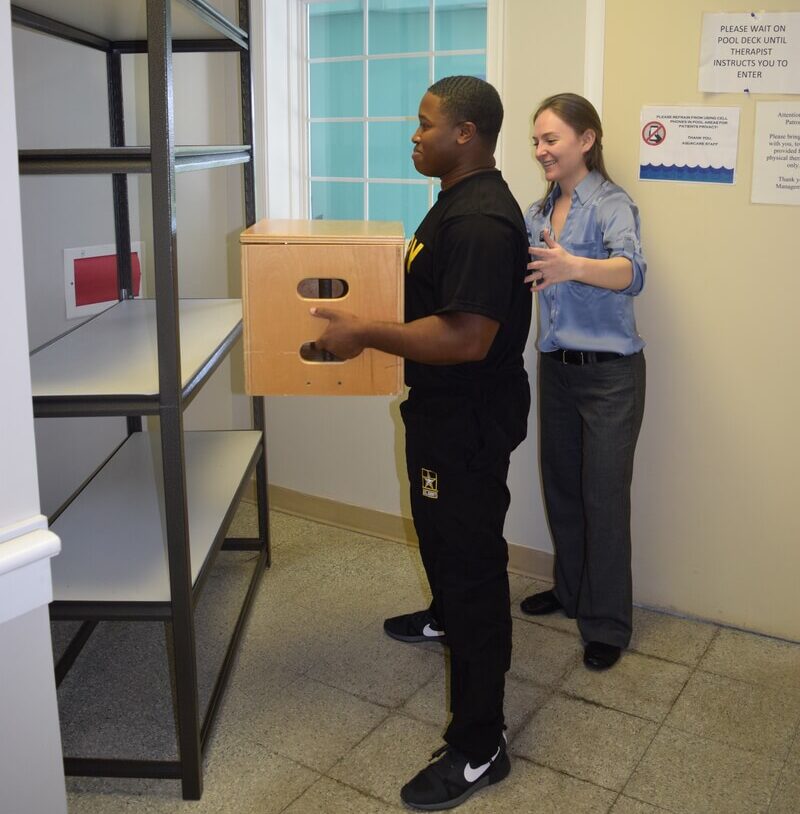 Injured worker box lifting smiling