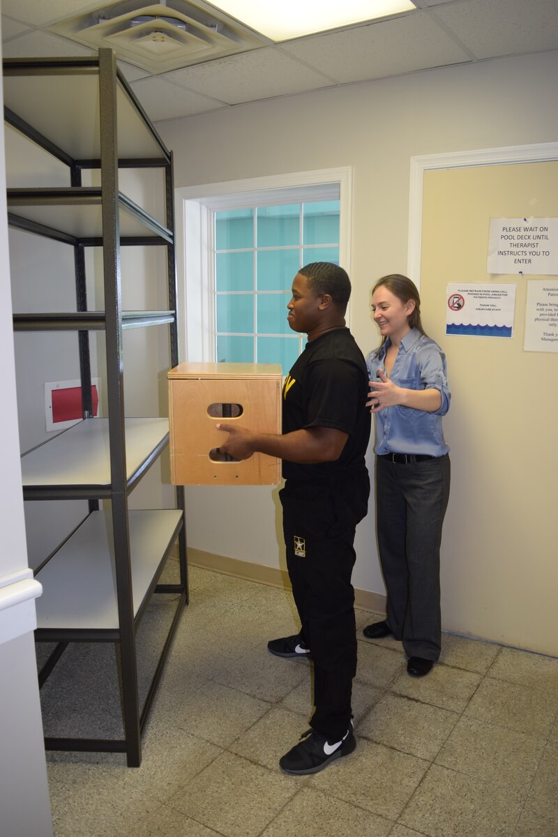 Injured worker box lifting smiling