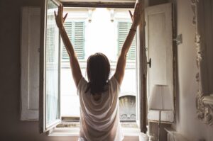 woman stretching in front of window