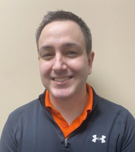 a man wearing an orange and black shirt