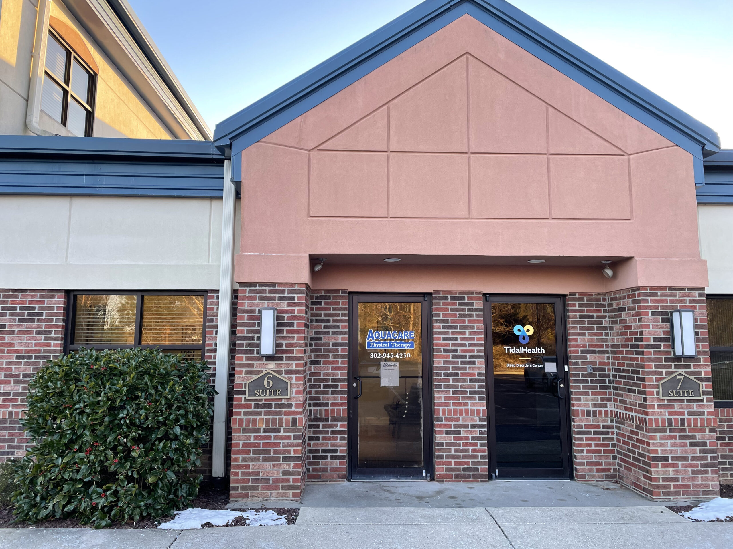 the front entrance to a building with a clock on it