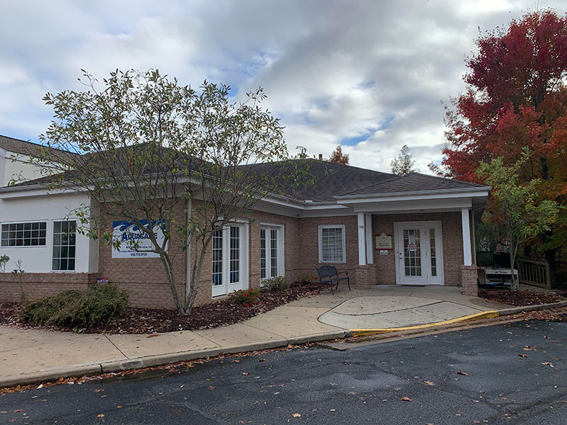 the front of a building with a parking lot