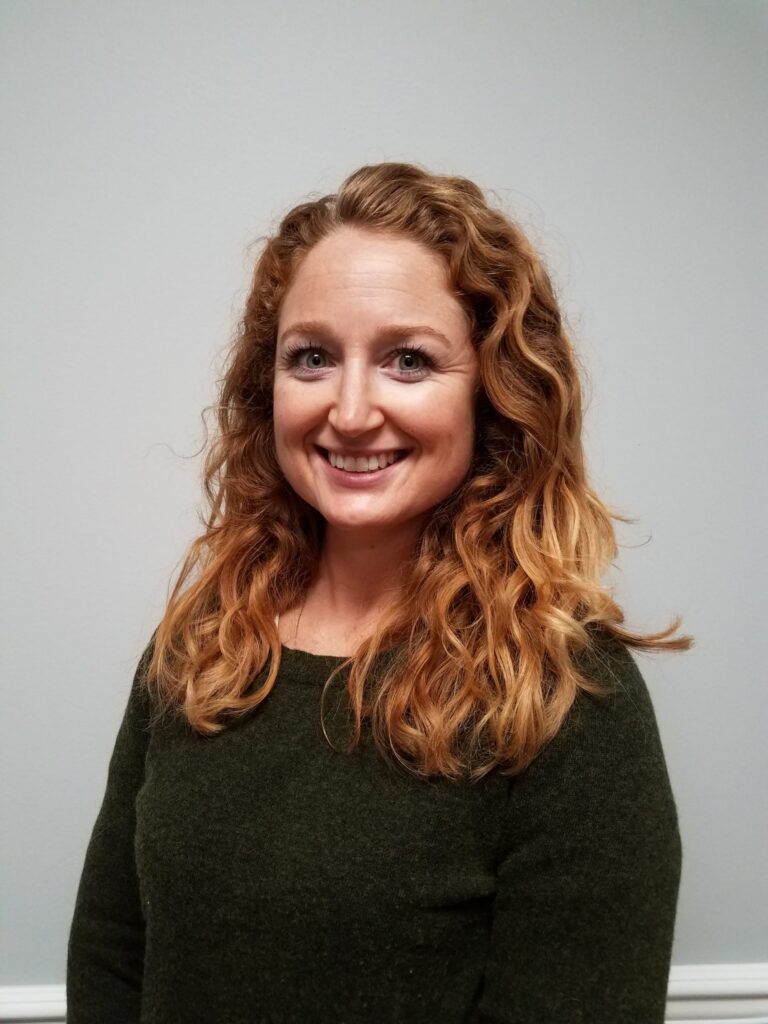 a woman with curly hair is smiling for the camera