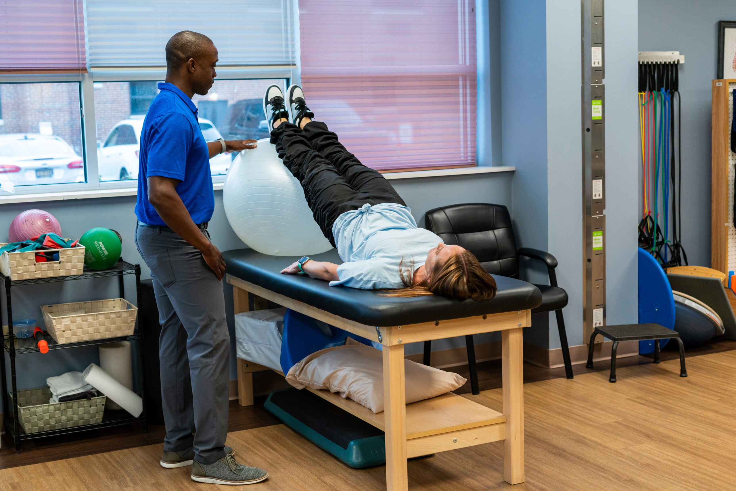 a man standing over a woman laying on a massage table