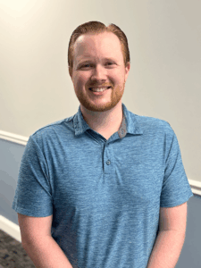 a man in a blue shirt standing in a room