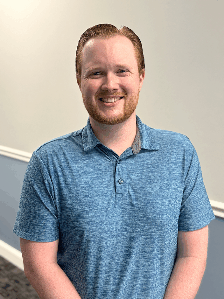 a man in a blue shirt standing in a room