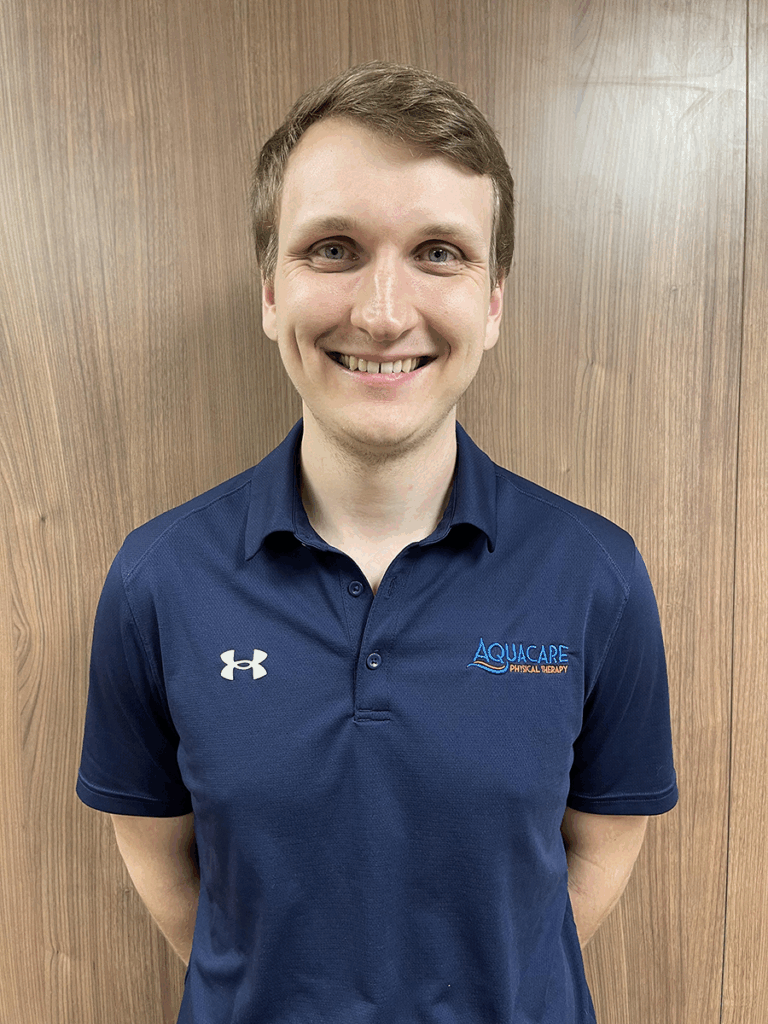 a man standing in front of a wooden wall
