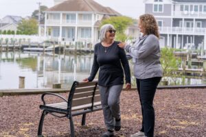 a couple of women standing next to a bench