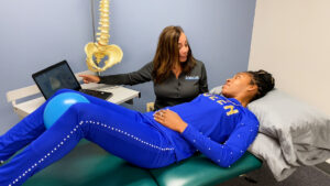 a woman in blue is laying on a green bed