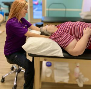 a woman is getting a back massage from a doctor