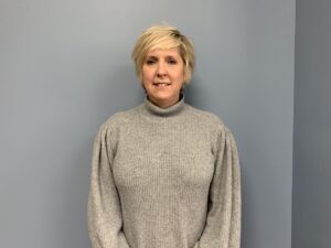 a woman standing in front of a gray wall
