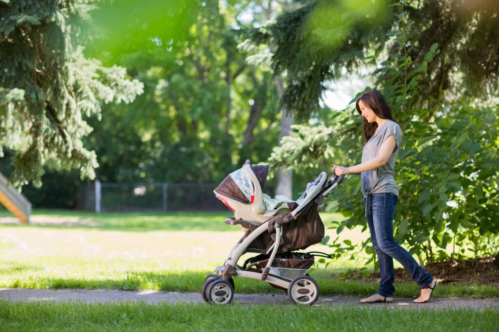 a woman pushing a stroller with a baby in it