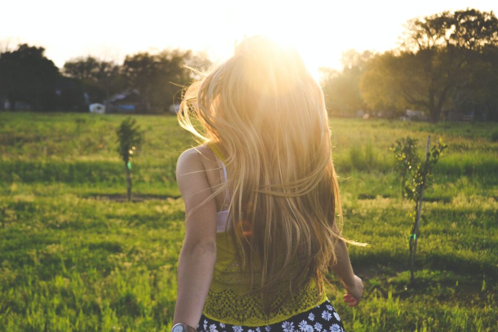 a woman standing in a field with her back to the camera