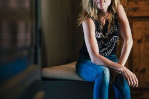 a woman sitting on top of a wooden bench