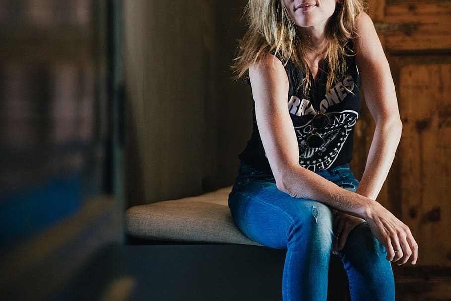 a woman sitting on top of a wooden bench