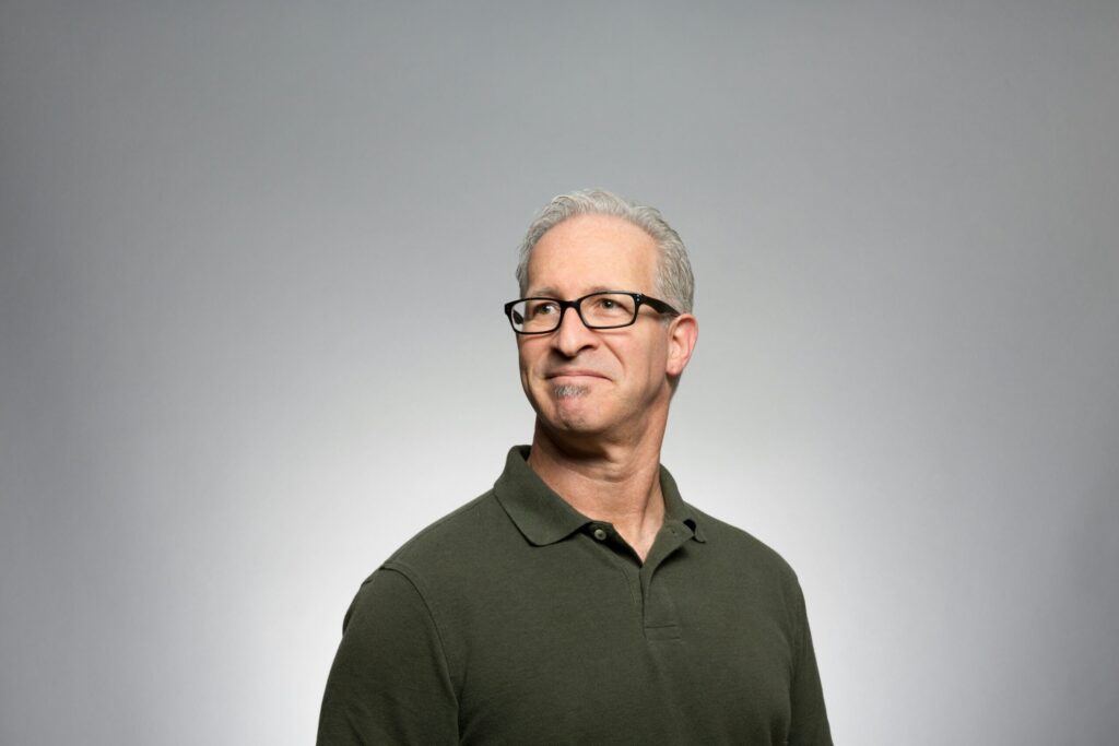 a man with glasses is posing for a picture