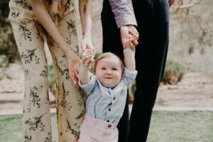 a little girl holding the hand of her mother