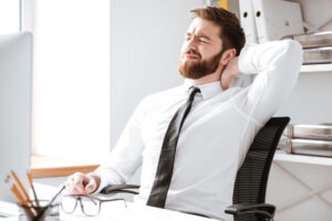 a man sitting at a desk with his head in his hands