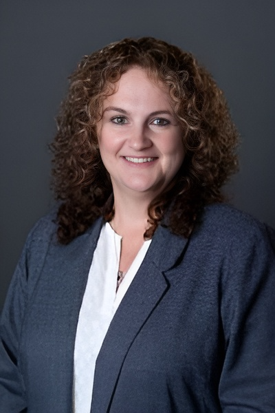 a woman with curly hair wearing a blue jacket