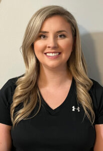 a woman in a black shirt is smiling at the camera