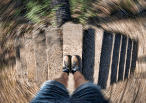 a person standing on a wooden walkway with their feet in the air