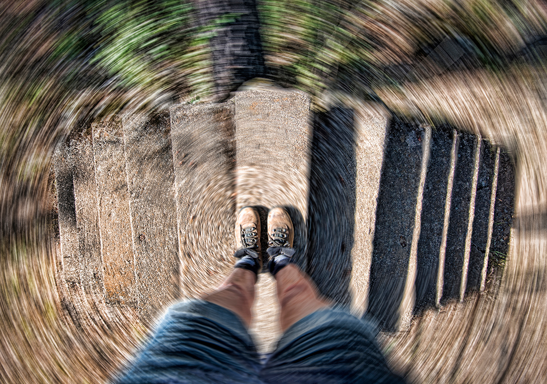 a person standing on a wooden walkway with their feet in the air