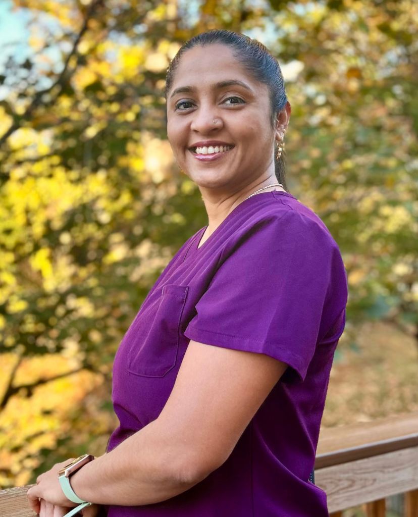a woman in a purple shirt is smiling