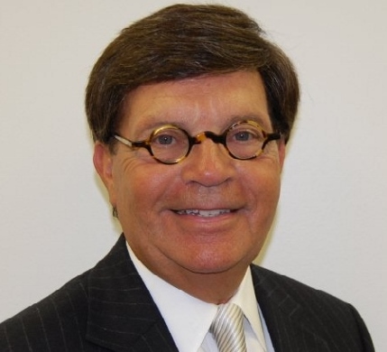 a man in a suit and tie smiling for the camera