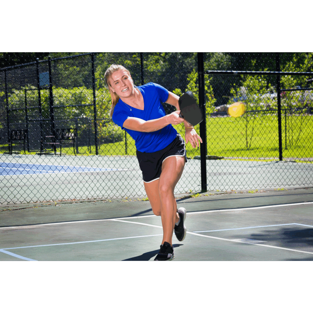 a woman in blue shirt and black shorts playing pickleball