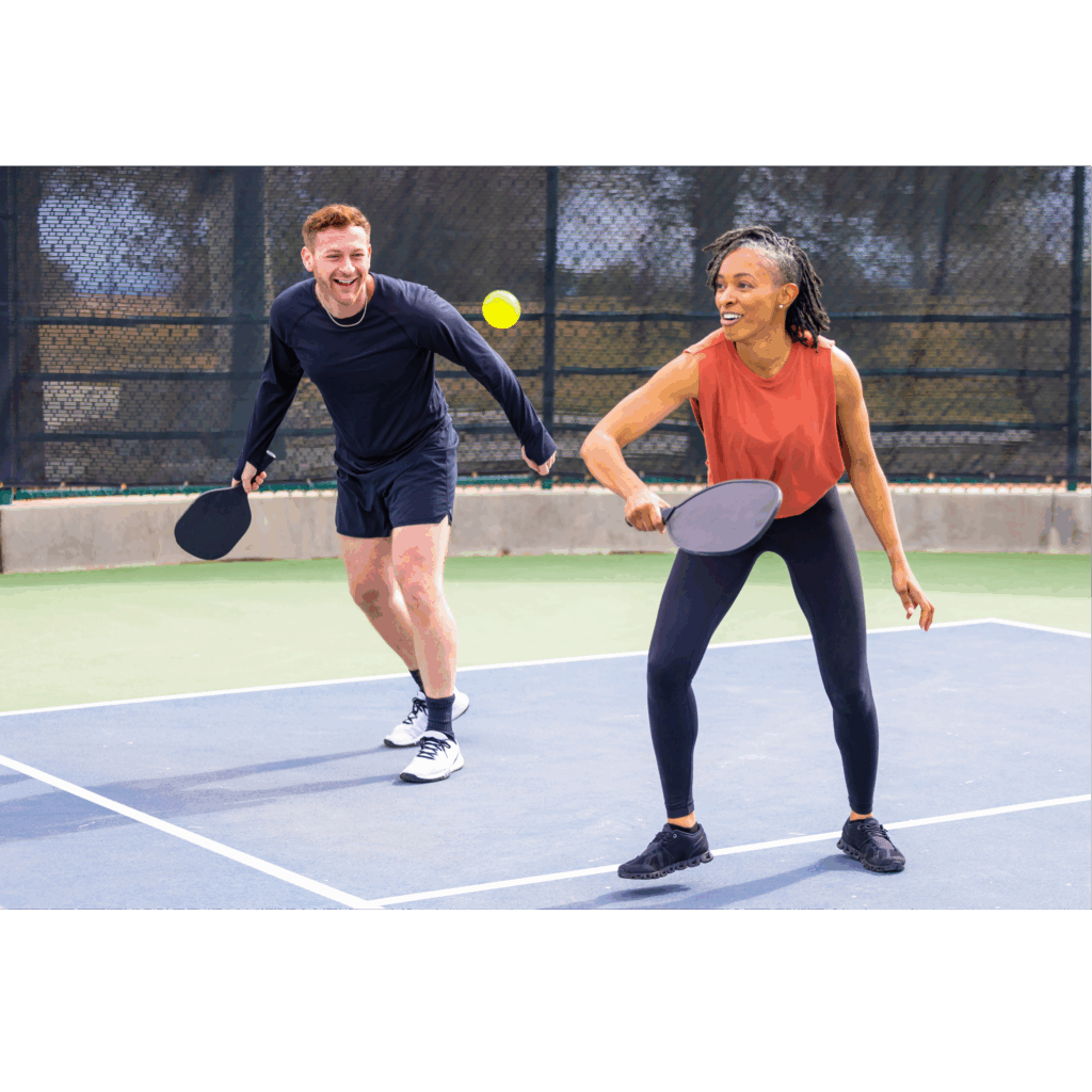 a man and woman playing pickleball on a court