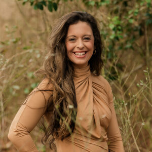 a woman standing in tall grass with her hands on her hips