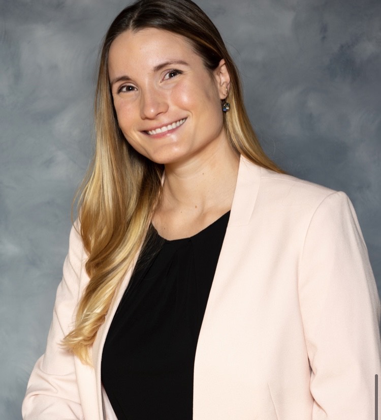 a woman in a pink blazer and black top