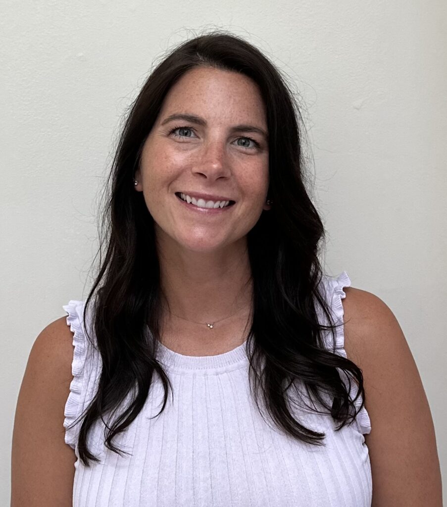 a woman in a white top smiling at the camera