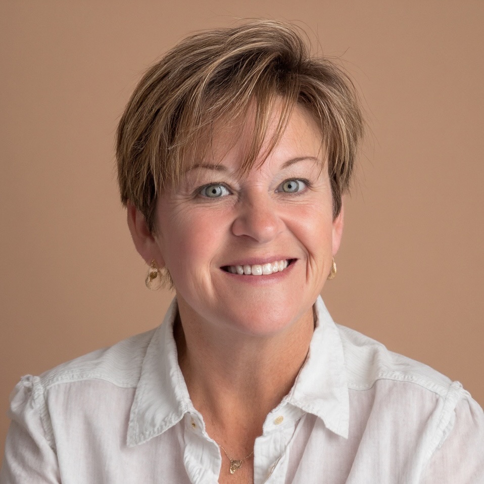 a woman in a white shirt smiling at the camera