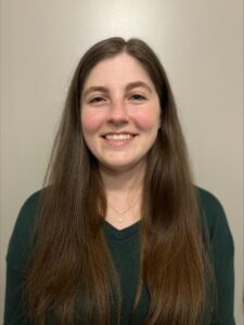 a woman with long brown hair and a green shirt