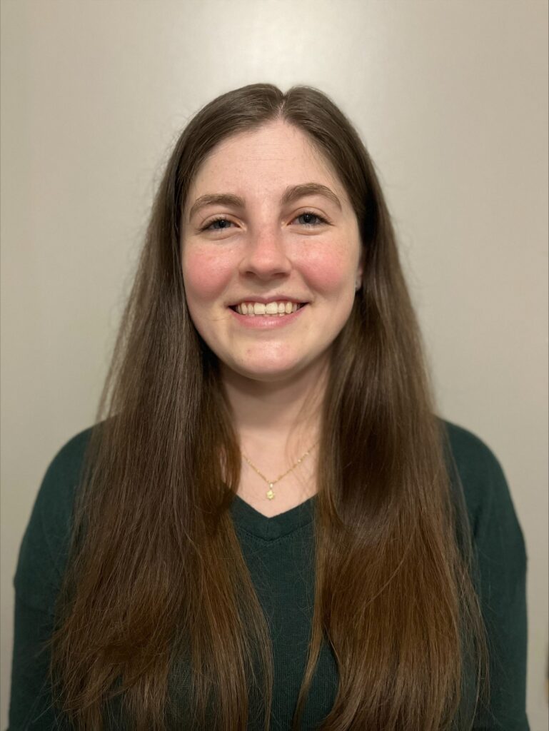 a woman with long brown hair and a green shirt