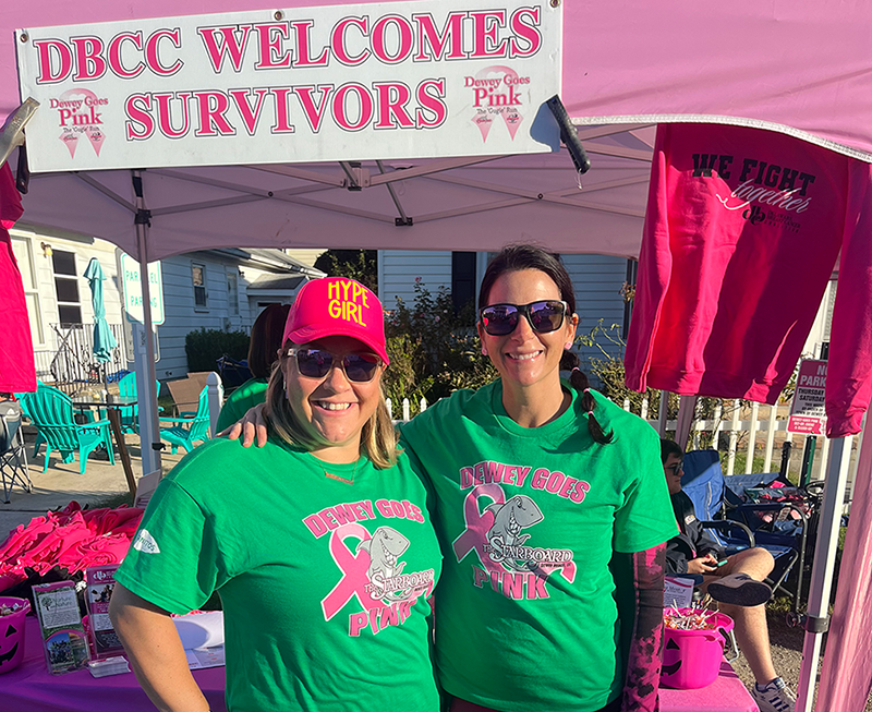 a couple of women standing next to each other under a tent