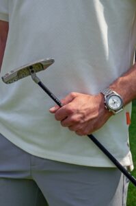 a man holding a golf club and a golf ball