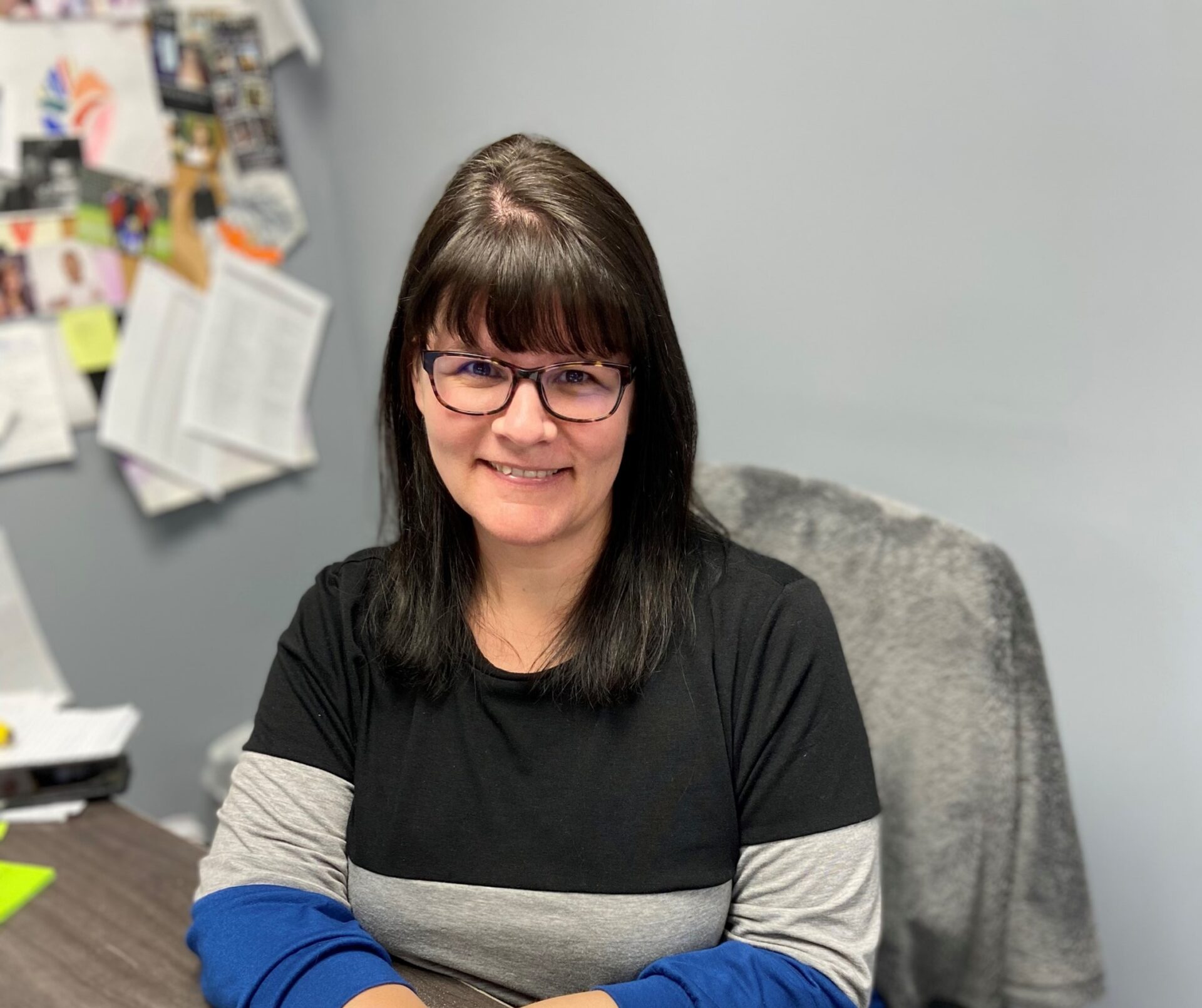 a woman sitting at a desk with her arms crossed