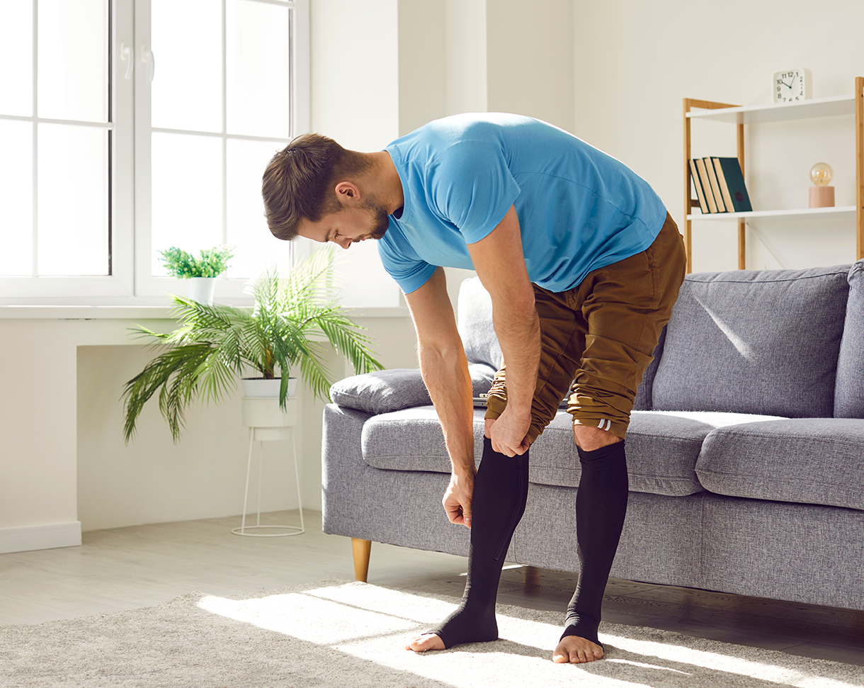 a man in a blue shirt and brown pants is standing in front of a couch