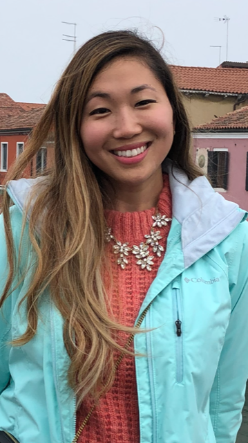 a woman standing in front of some buildings