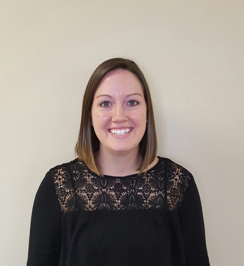 a woman standing in front of a white wall