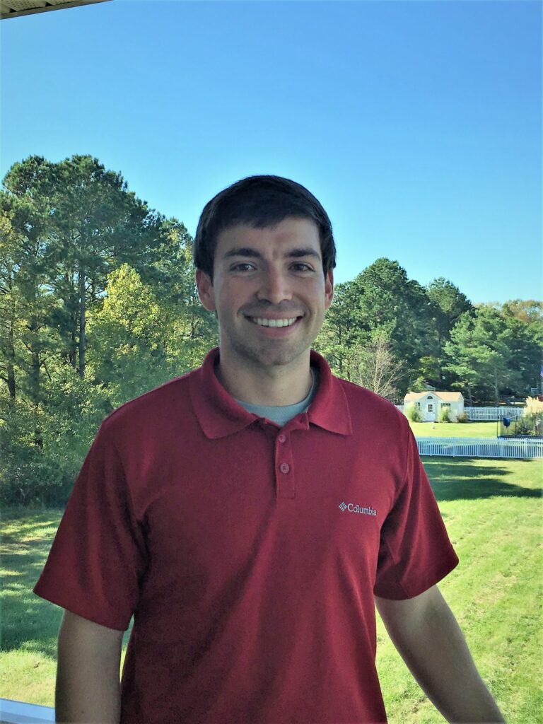 a man in a red shirt is smiling for the camera