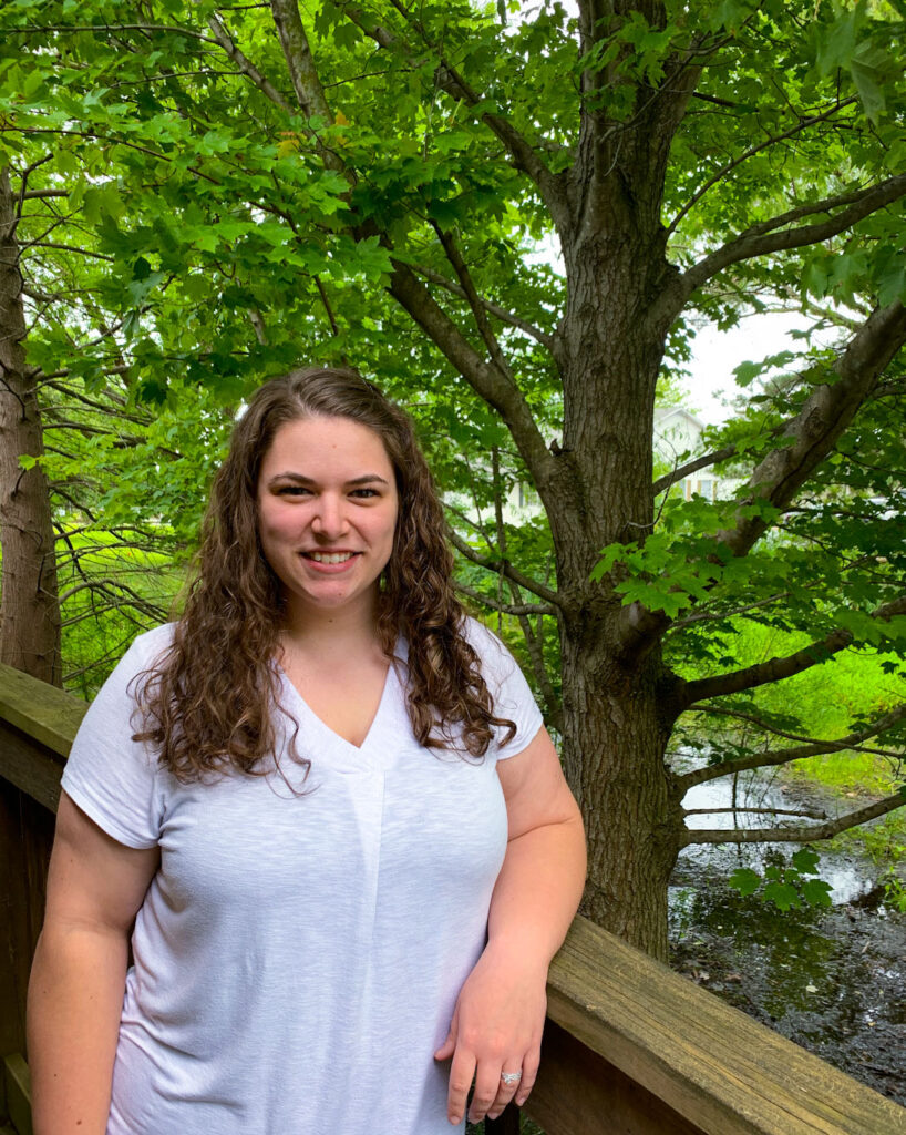 a woman standing on a bridge next to a tree