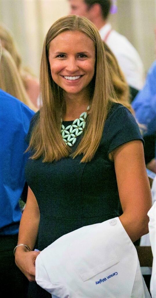 a smiling woman holding a white piece of paper