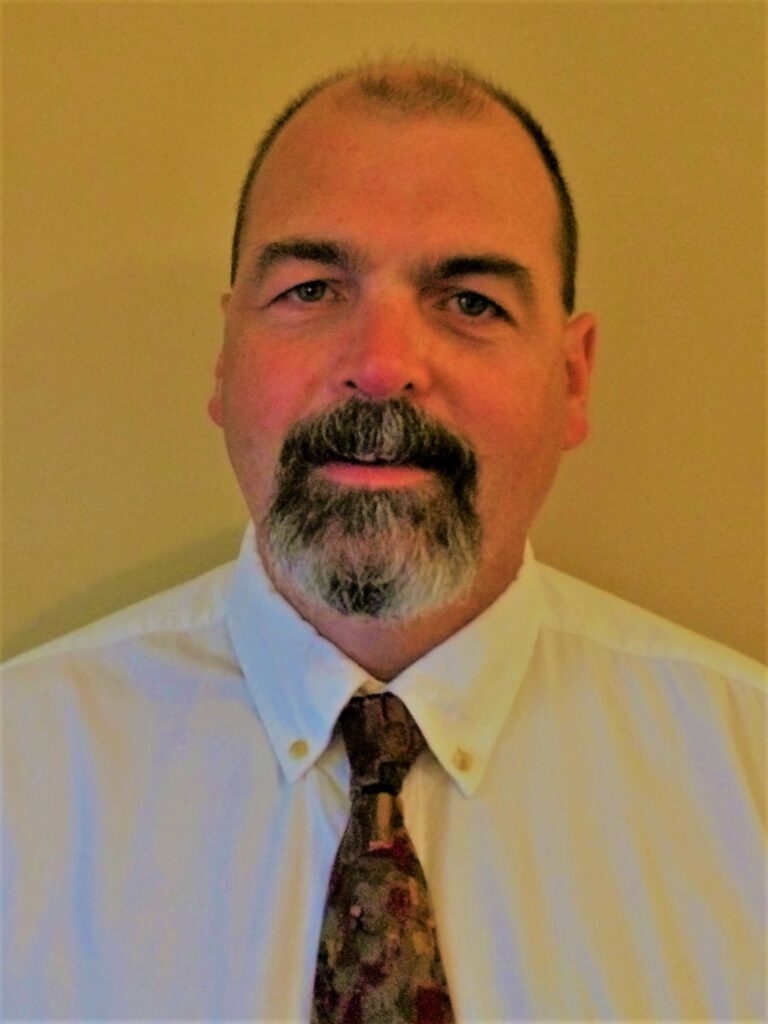 a man with a beard wearing a white shirt and tie