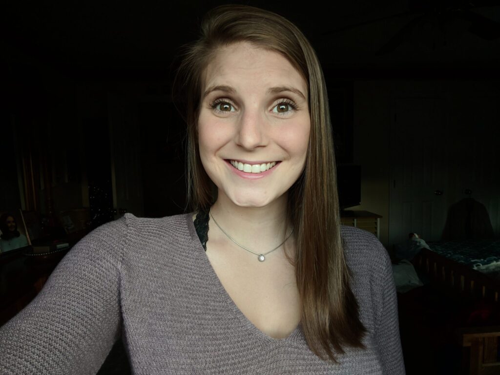 a woman with long brown hair smiling at the camera