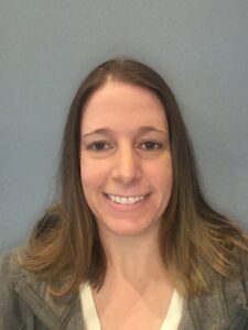 a woman with long brown hair smiling at the camera